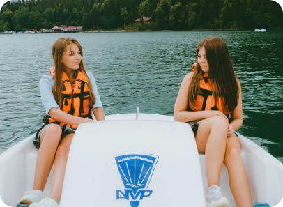 Picture of two girls in a white peddle boat on a lake
